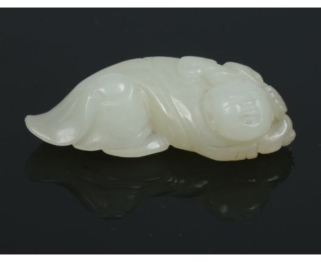 A late 19th century Chinese small celadon jade carving of a reclining boy holding a ruyi branch over his shoulder, 4cm wide. 
