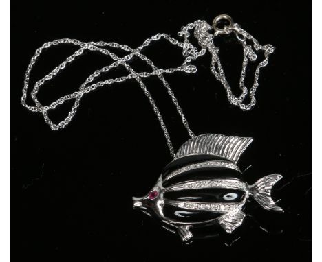An 18 carat white gold pendant formed as a fish. Decorated with alternating bands of black enamel and diamonds and with a rub