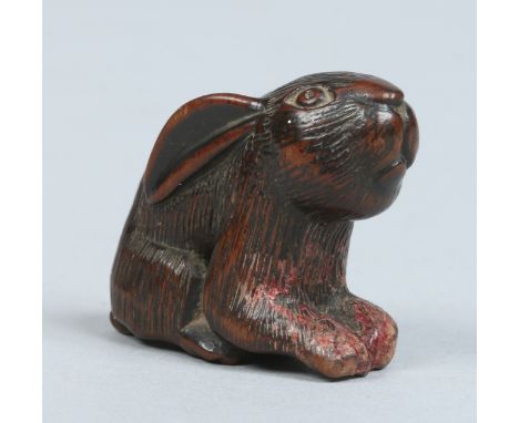 A Japanese Edo period wooden netsuke carved in the form of a crouching hare, 3.75cm high.   Condition Report. To be used as a
