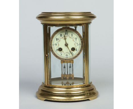 An early 20th century French brass cased oval four glass mantel clock with enamel dial having white paste set bezel. Housing 