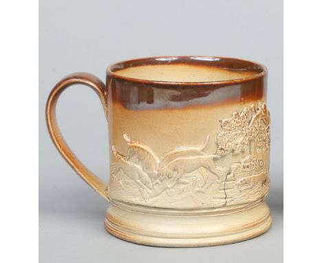 A 19th century saltglaze stoneware frog mug. With plain strap handle and sprigged with a fox hunting scene, 10cm high.   Cond