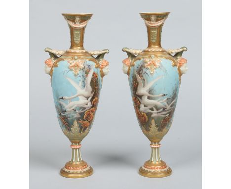 A pair of Royal Worcester pedestal vases by Charles Baldwyn. With moulded twin mask handles and painted with swans in flight 