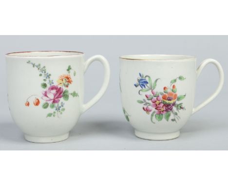 Two Worcester coffee cups each with grooved loop handles and coloured in enamels with flowers, one with gilt rim and the othe