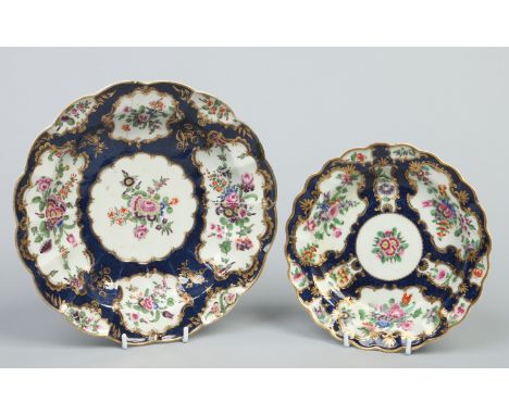 Two Worcester lobed plates. Scale blue ground and with gilt cartouches enamelled with flowers. Underglaze square seal marks. 