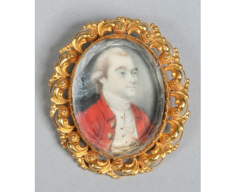 A 19th century ivory portrait miniature of a gentleman in scroll work yellow metal frame, 4.75cm high.