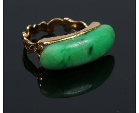A yellow metal ring with scrolling shank and set with jade band. Size K.   Condition Report. To be used as a guide only.  Goo