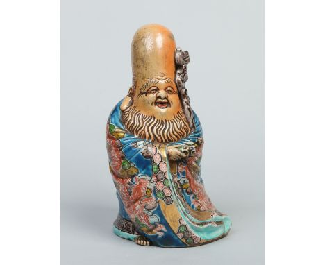 A Chinese figure of Shou Lao holding a gnarled staff and a scroll. Dressed in a blue glazed flowing robe enamelled with drago