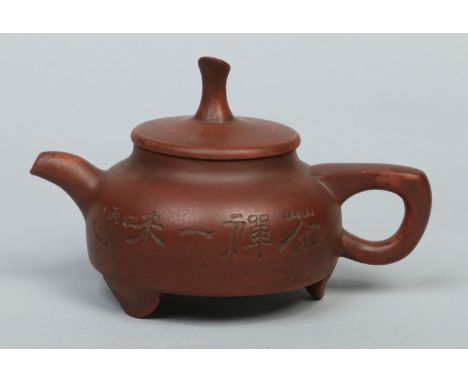 A Chinese yixing teapot and cover decorated with incised character marks and bamboo shoots. Impressed seal mark, 18cm handle 