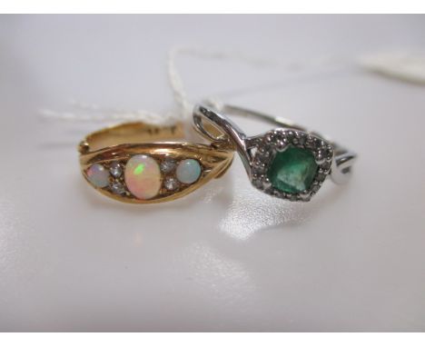 A 9ct white gold emerald and diamond set ring and a cased opal and diamond boat shaped ring stamped '18ct' (2)  