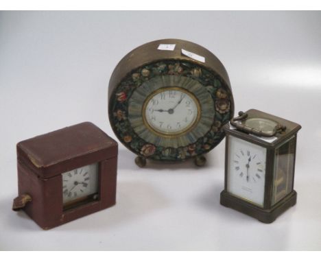 Two carriage clocks, a watch in leather holder, mantel clock with floral surround and a desk watch, all in need of attention 