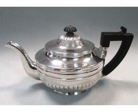 A George III silver teapot, by William Bennett, London 1804, of circular shape, half gadrooned below a moulded girdle, reeded