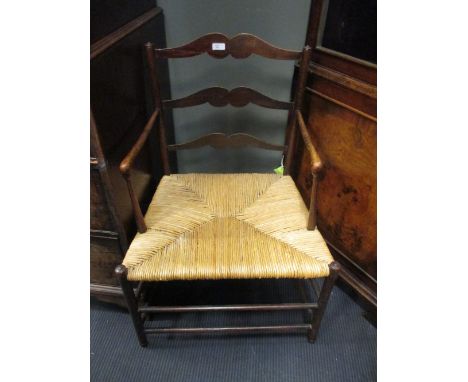 An Arts and Crafts period ash ladder back armchair with a rush seat  