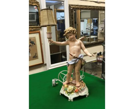 An early 20th Century Schierholz porcelain table lamp as a cherub holding aloft a torch CONDITION REPORTS Whilst over all loo