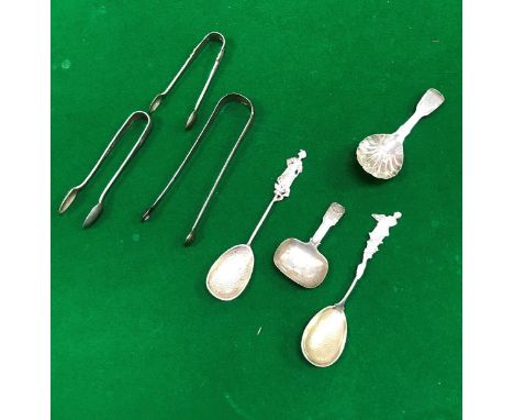 A collection of silver wares to include three pairs of sugar tongs, two decorative spoons with figural finials and a George I
