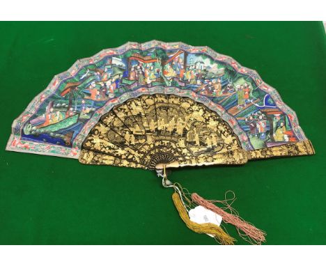 A 19th Century black lacquered and gilt decorated Chinese Qing Dynasty polychrome painted fan decorated with multiple figures