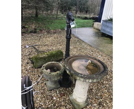 A pair of composite stone garden urns, together with a similar bird bath, a painted cast metal tying post and a lawn roller