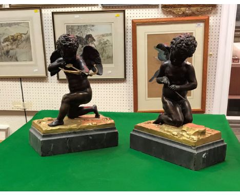 A pair of 19th Century Continental chocolate patinated bronze figures of cherubs, one aiming a gilt bronze bow and arrow, the