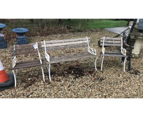 An early 20th Century wrought iron and slatted wooden three piece garden suite, comprising bench and two standard chairs, tog