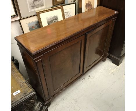 A 19th Century mahogany dwarf cupboard, the top with reeded edge over two panelled doors and enclosing a shelf, raised on tur