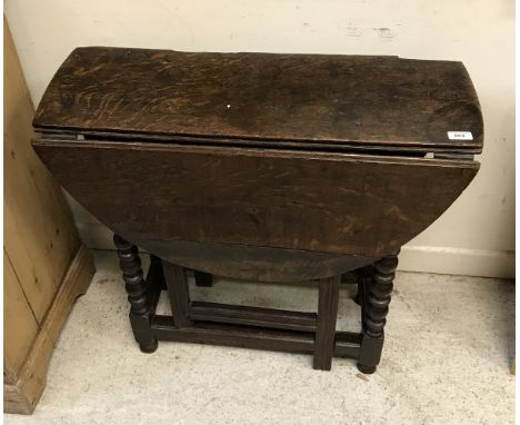 A late 17th Century oak oval gateleg drop-leaf dining table on bobbin-turned supports united by stretchers