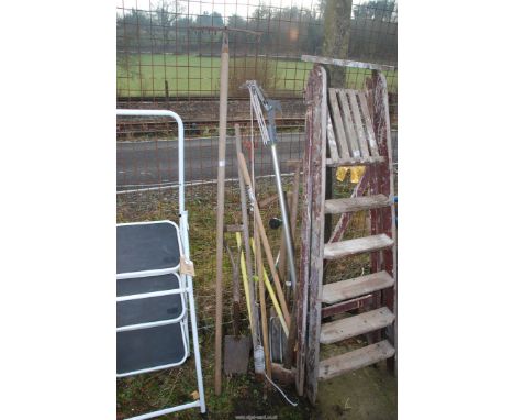 A quantity of garden tools:  rake, pruner, stainless steel fork and sledge hammer.