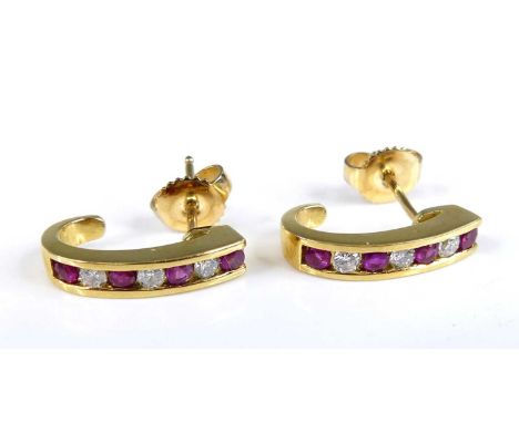 A pair of modern 18ct gold ruby and diamond set earrings, arranged as alternating channel set round cuts, total diamond weigh