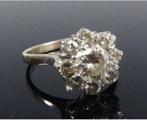 An 18ct white gold diamond circular cluster ring, comprising nine round brilliant cut diamonds in claw settings, centre diamo