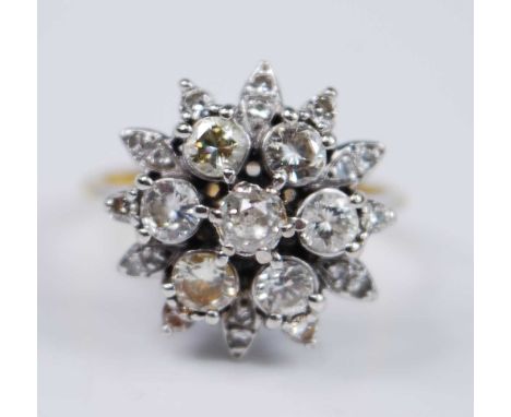 A yellow and white metal diamond flower shaped cluster ring, comprising a centre Old European cut diamond within a border of 