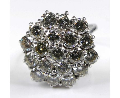 An 18ct white gold diamond circular cluster ring, featuring 19 round brilliant cut diamonds in tiered claw settings, diamond 