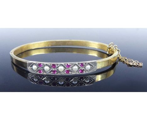 A yellow and white metal hinged hollow oval bangle, having an engraved rectangular section to the centre set with eight 1.85m