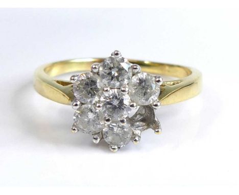 An 18ct gold diamond flower head cluster ring, arranged as seven round cuts in a tiered flower head setting (one stone defici