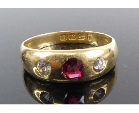 An 18ct yellow gold ruby and diamond dress ring, comprising a centre oval ruby and two Old European cut diamonds, all in flus