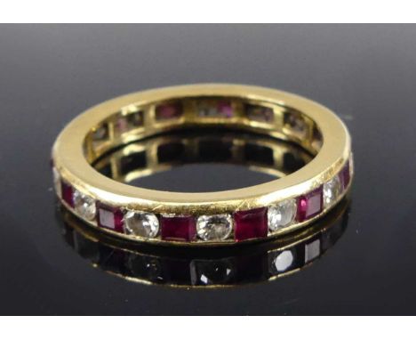 A yellow metal ruby and diamond eternity ring comprising 14 rectangular rubies alternating with 14 round brilliant cut diamon