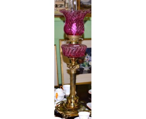 A reproduction cranberry glass and brass table lamp, in the form of an oil lamp (converted) 