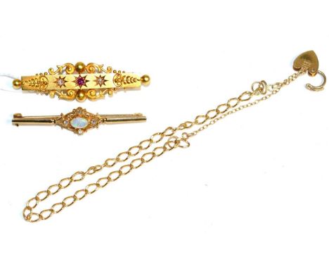 A 15 carat gold ruby and diamond brooch, a star set ruby spaced by two old cut diamonds, to a scroll bar, total estimated dia