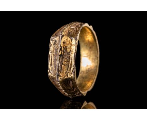 Ca. AD 1400.A medieval British silver gilt iconographic ring with a round hoop, divided by high mid-rib and embellished with 