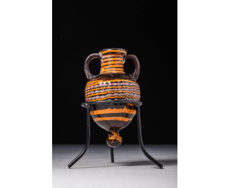 Ca. 600 - 400 BC.A core-formed amphoriskos crafted from aubergine-coloured glass. It has an inverted pear-shaped body that ta
