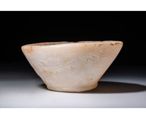 Old Kingdom, Ca. 2575-2134 BC.A carved stone bowl of soft yellow-white hues that illuminate next to a light source. The conic