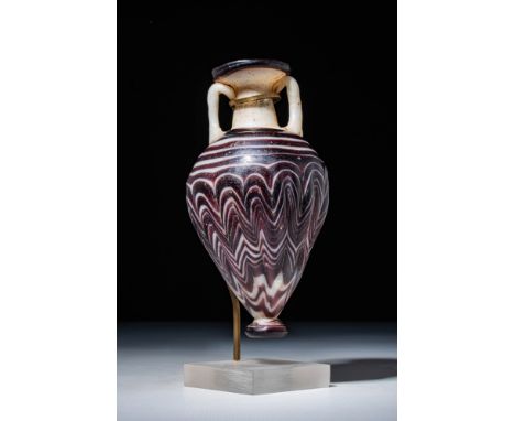 Eastern Mediterranean, Ca. 600 - 400 BC.A core-formed amphoriskos crafted from opaque white and dark purple glass. It has an 