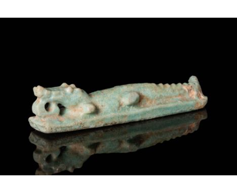 Ca. 664 - 332 BC.A faience amulet of a crocodile featuring an elongated body with detailed naturalistic characteristics. The 