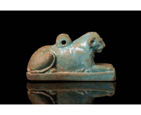 Late Period, Ca. 664 - 332 BC.An exceptional mould-formed faience lion amulet shown in a recumbent pose. The resting feline i