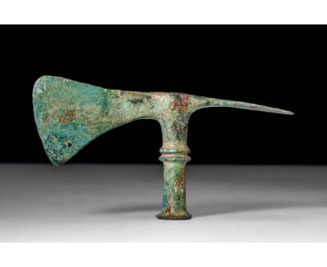 Ca. 1200 - 800 BC.A Western Asiatic cast bronze axe head with two distinct faces. Stemming from the upper shaft are two axe f