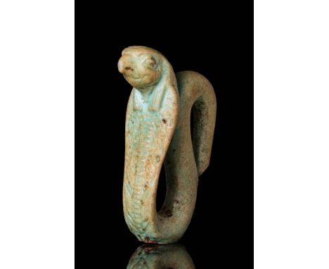 Ca. 664 - 332 BC.A mould-formed faience amulet depicting a cobra with its falcon head and tripartite wig. A pierced suspensio