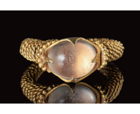 Ca. AD 600 - 900.A Javanese gold ring with twisted threads. The ring is crowned with a large frame of gold pellets on the sho