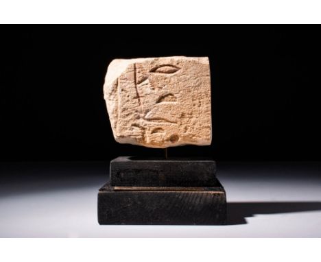 Ca. 2680 - 2160 BC.A thick limestone fragment featuring the partial remains of a carved hieroglyphic inscription. Mounted on 