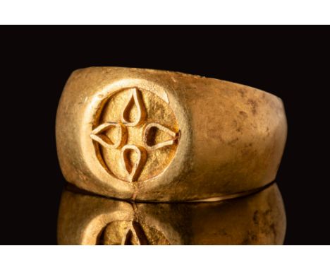 Ca. AD 500 - 700.A Byzantine gold ring with a round hoop and a circular bezel. On the bezel there is a cross motif formed wit
