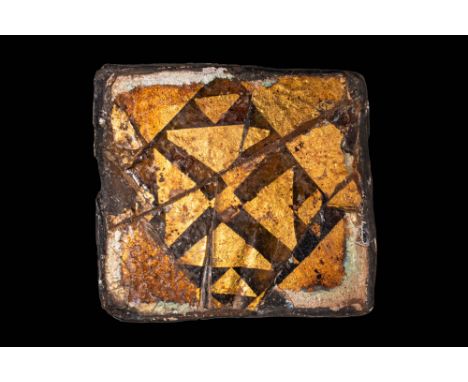 Ca. AD 1000 - 1200.A square sandwich glass tile featuring geometric motifs in gold and black. The central pattern is triangle