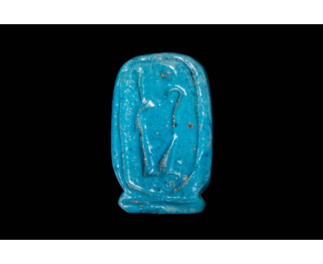 New Kingdom, Ca. 1550 - 1069 BC.A blue faience amulet with cartouche form inscribed with hieroglyphic script on the top and a