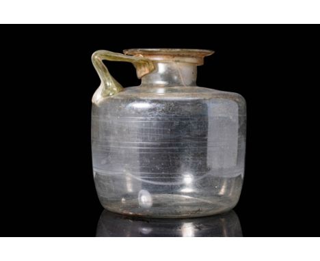 Ca. AD 100 - 300.A Roman mold-blown translucent glass bottle with a concave base, a cylindrical body and a rounded shoulder. 