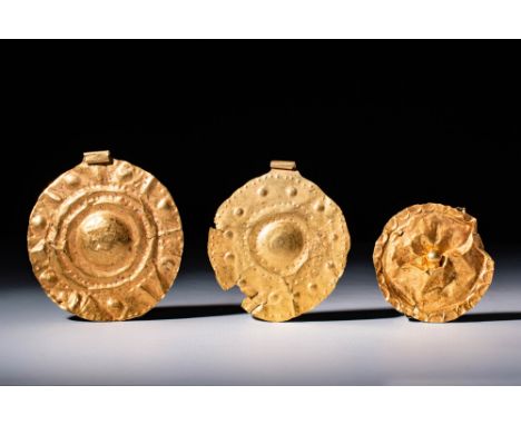 Ca. 300 - 100 BC.A group of three circular gold medallions, each with a flat section and a raised central boss encircled by d